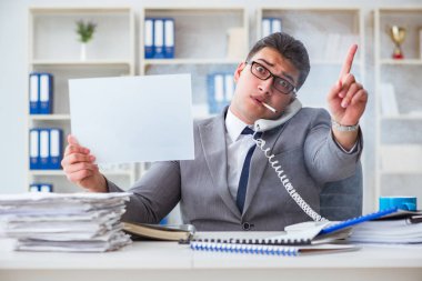 Ofiste sigara içen bir iş adamı elinde boş bir mesaj tutuyor.