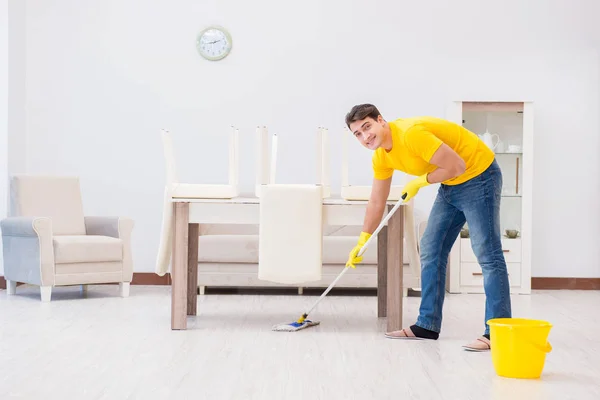 Jovem fazendo tarefas em casa — Fotografia de Stock