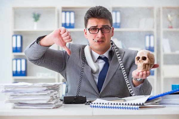 Businessman in the office smoking holding human skull — Stock Photo, Image