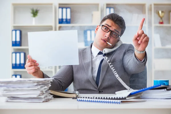 Ofiste sigara içen bir iş adamı elinde boş bir mesaj tutuyor.