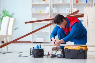 Genç marangoz ahşap kalaslarla çalışıyor.