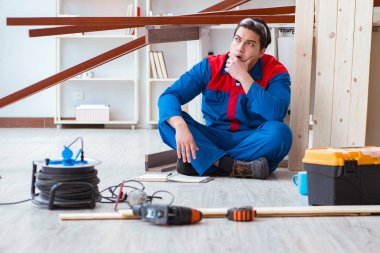 İnşaatta defter planlama yapan genç bir marangoz.