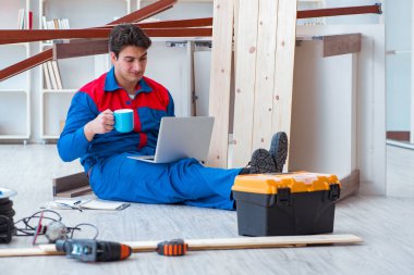 Dizüstü bilgisayarı olan genç bir marangoz