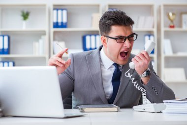 İşadamı ofisinde sigara içiyor.