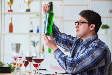Profesyonel şarap garsonu kırmızı şarap tadıyor.