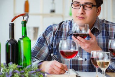 Profesyonel şarap garsonu kırmızı şarap tadıyor.