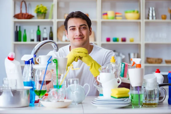 Мужчина наслаждается мытьем посуды дома — стоковое фото
