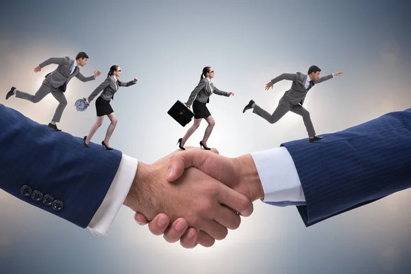 Cooperation concept with people running on handshake — Stock Photo, Image