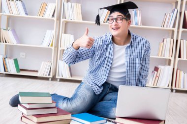 Genç öğrenci kitaplarla çalışıyor.