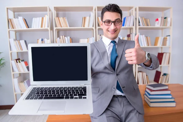 Affärsman med en tom bärbar dator som arbetar i biblioteket — Stockfoto