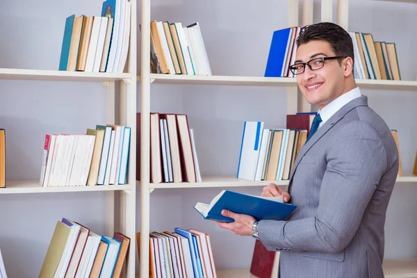 Estudante de negócios lendo um livro estudando na biblioteca — Fotografia de Stock