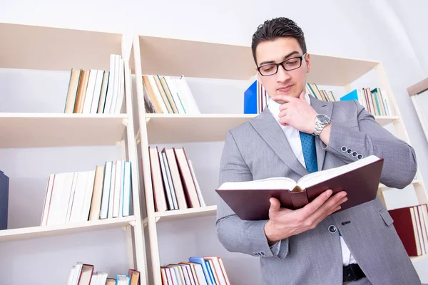 Студент-бізнесмен читає книгу, що навчається в бібліотеці — стокове фото