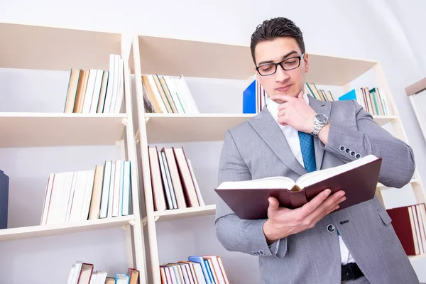 Affärsman student läser en bok som studerar i biblioteket — Stockfoto