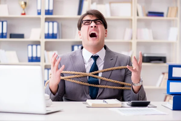 Businessman tied up with rope in office — Stock Photo, Image