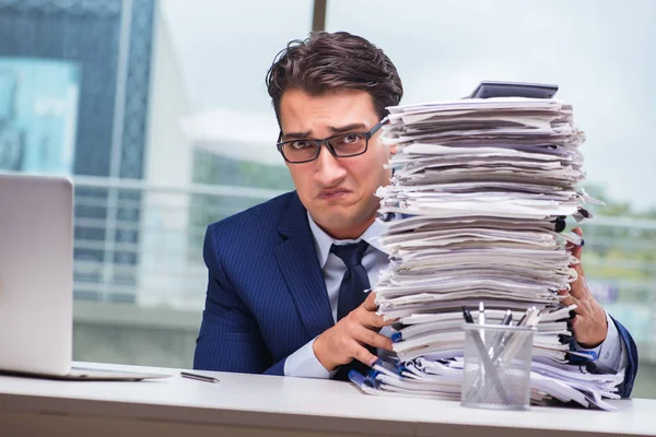 Geschäftsmann mit stapelweise Papierkram im Büro — Stockfoto