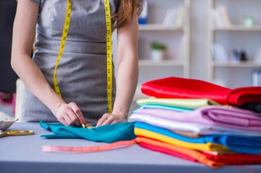 Kadın terzi dikiş dikmek için dikiş dikiyor.