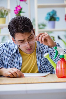 Çiçekçide çalışan genç bir adam.