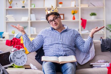 Genç adam dağınık bir odada çalışıyor.