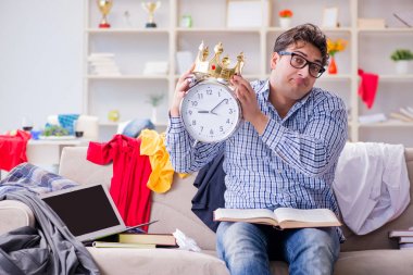 Genç adam dağınık bir odada çalışıyor.