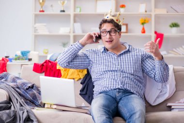 Genç adam dağınık bir odada çalışıyor.