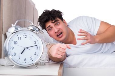 Yatakta uykusuzluk çeken bir adam.