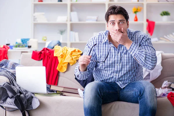 Joven trabajando estudiando en una habitación desordenada — Foto de Stock