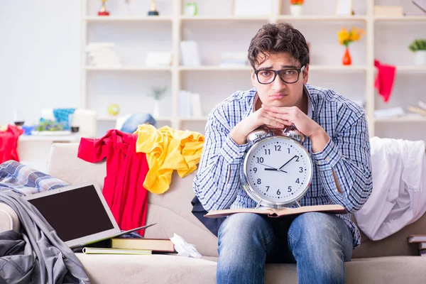 Joven trabajando estudiando en una habitación desordenada — Foto de Stock