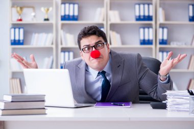 Ofiste çalışan palyaço işadamı.