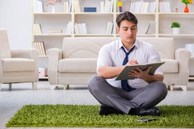 İş adamı ofiste yerde oturuyor.