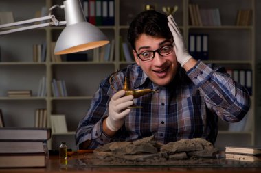 Arkeolog geç saatlere kadar ofiste çalışıyor.