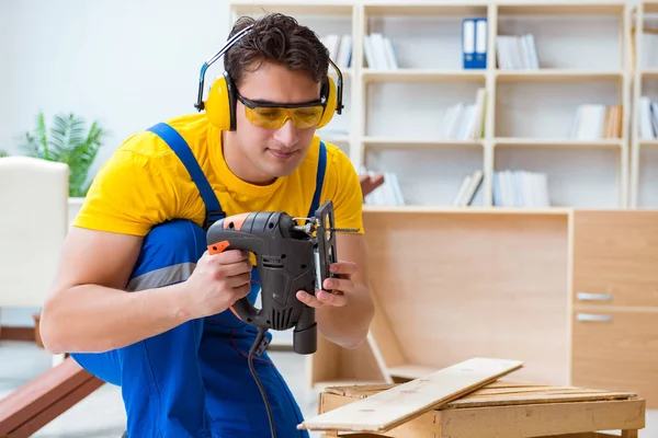 Reparador carpintero cortando aserrar una tabla de madera con un electr —  Fotos de Stock