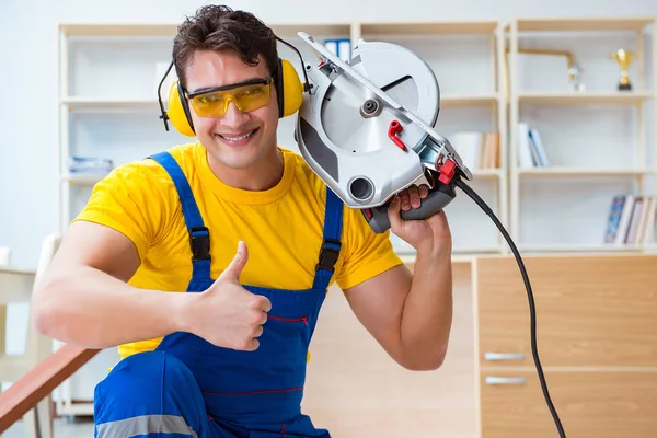Repairman carpenter cutting sawing a wooden plank with a circula — Stock Photo, Image