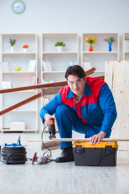 Genç marangoz ahşap kalaslarla çalışıyor.