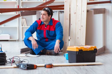 İnşaatta defter planlama yapan genç bir marangoz.