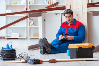 İnşaatta defter planlama yapan genç bir marangoz.