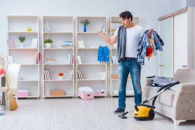Adam evi temizliyor.