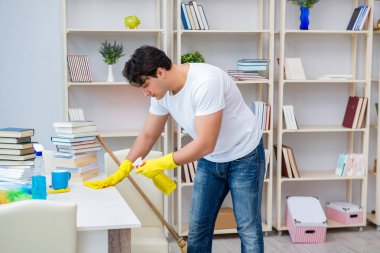 Adam evi temizliyor.