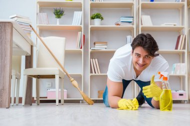 Adam evi temizliyor.