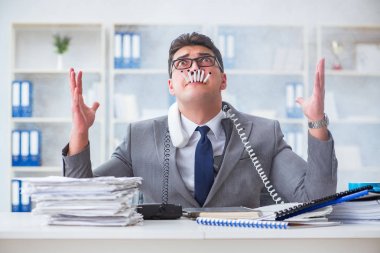 İşadamı ofisinde sigara içiyor.