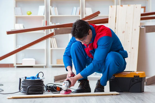 Genç marangoz ahşap kalaslarla çalışıyor.