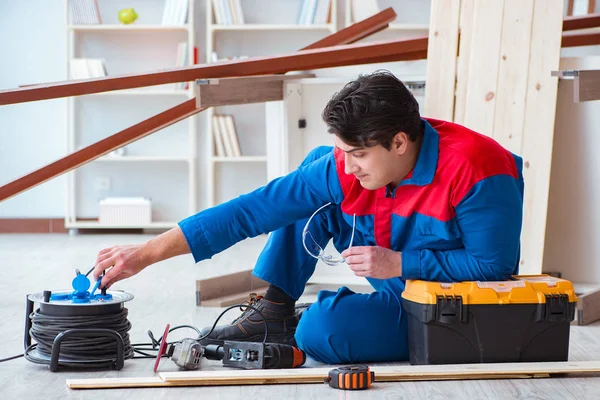 Genç marangoz ahşap kalaslarla çalışmaya ara veriyor.