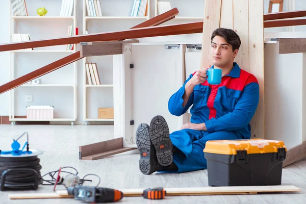 Genç marangoz ahşap kalaslarla çalışmaya ara veriyor.