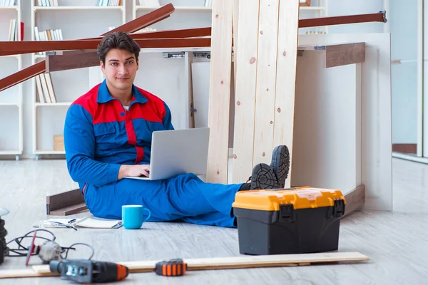 Dizüstü bilgisayarı olan genç bir marangoz