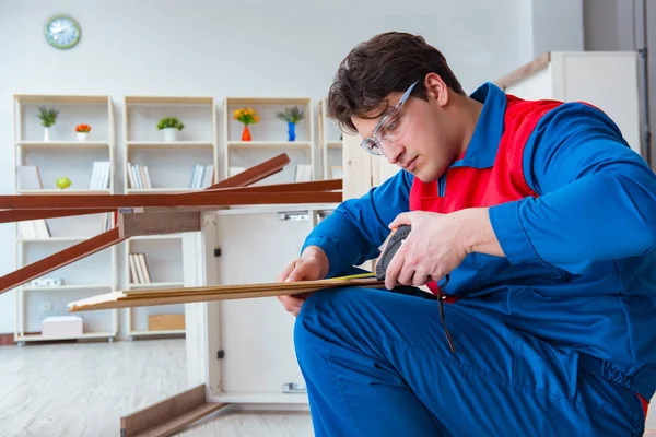 Genç marangoz ahşap kalaslarla çalışıyor.