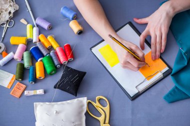 Kadın terzi dikiş dikmek için dikiş dikiyor.