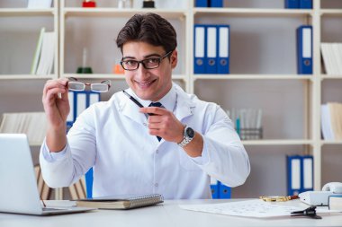 Doktor Optisyen elinde optik gözlük tutuyor.