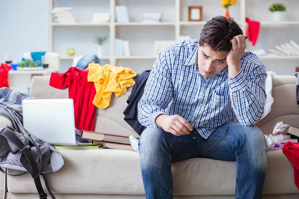 Joven trabajando estudiando en una habitación desordenada — Foto de Stock