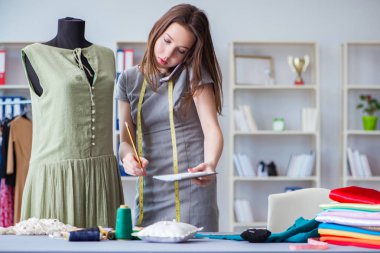 Kadın terzi dikiş dikmek için dikiş dikiyor.