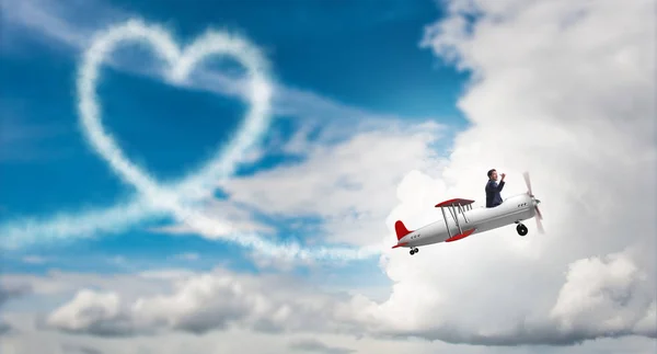Человек летит на самолете и придает форму сердцу — стоковое фото