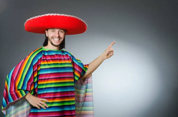 Uomo in un vivido poncho messicano sfondo grigio isolato — Foto Stock